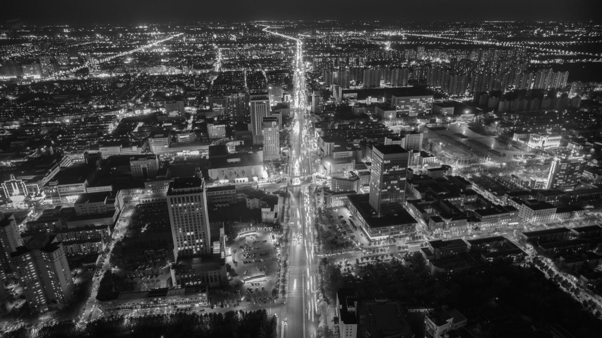 Black-and-white aerial view of an illuminated city at night