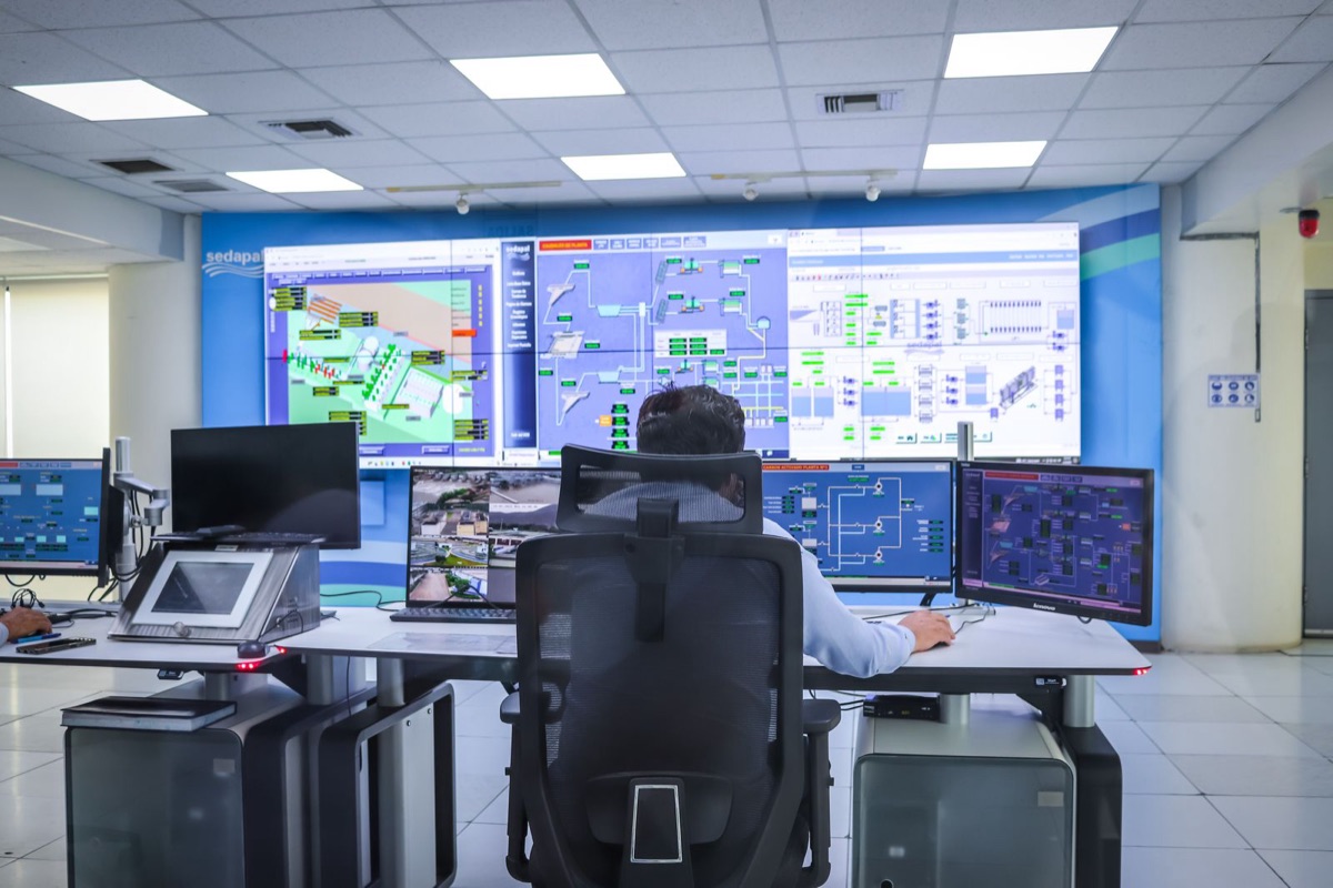 Advanced control room with operators at a wall of monitors
